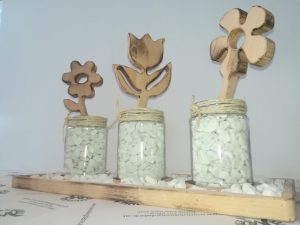 Dekoteller gefüllt mit Zierkiesel 3 Gläser mit Blumen aus Holz Buche